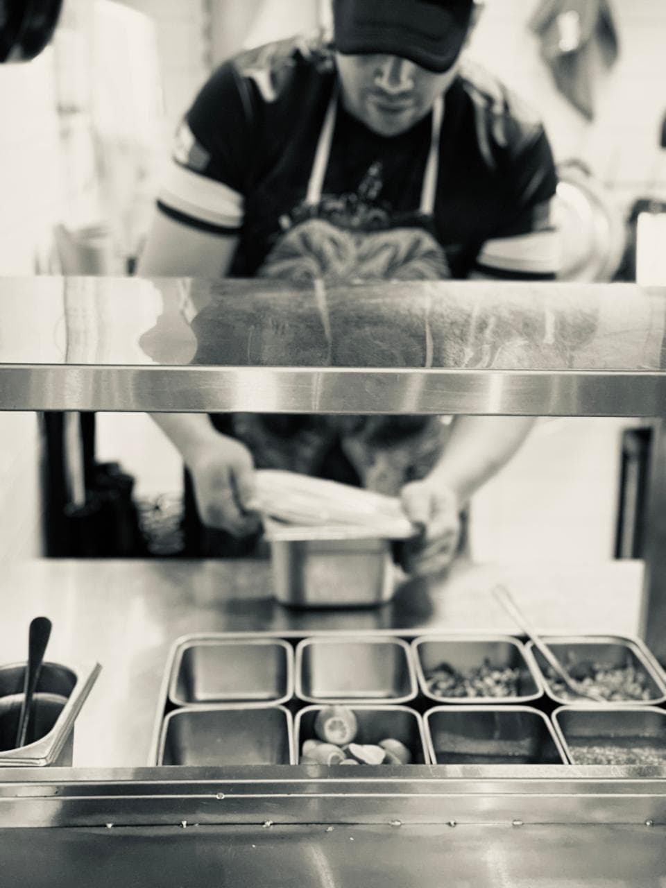 A chef working a service line of gastronorm pans